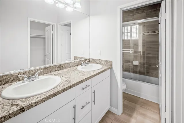 a bathroom with a granite countertop sink a mirror and a bathtub