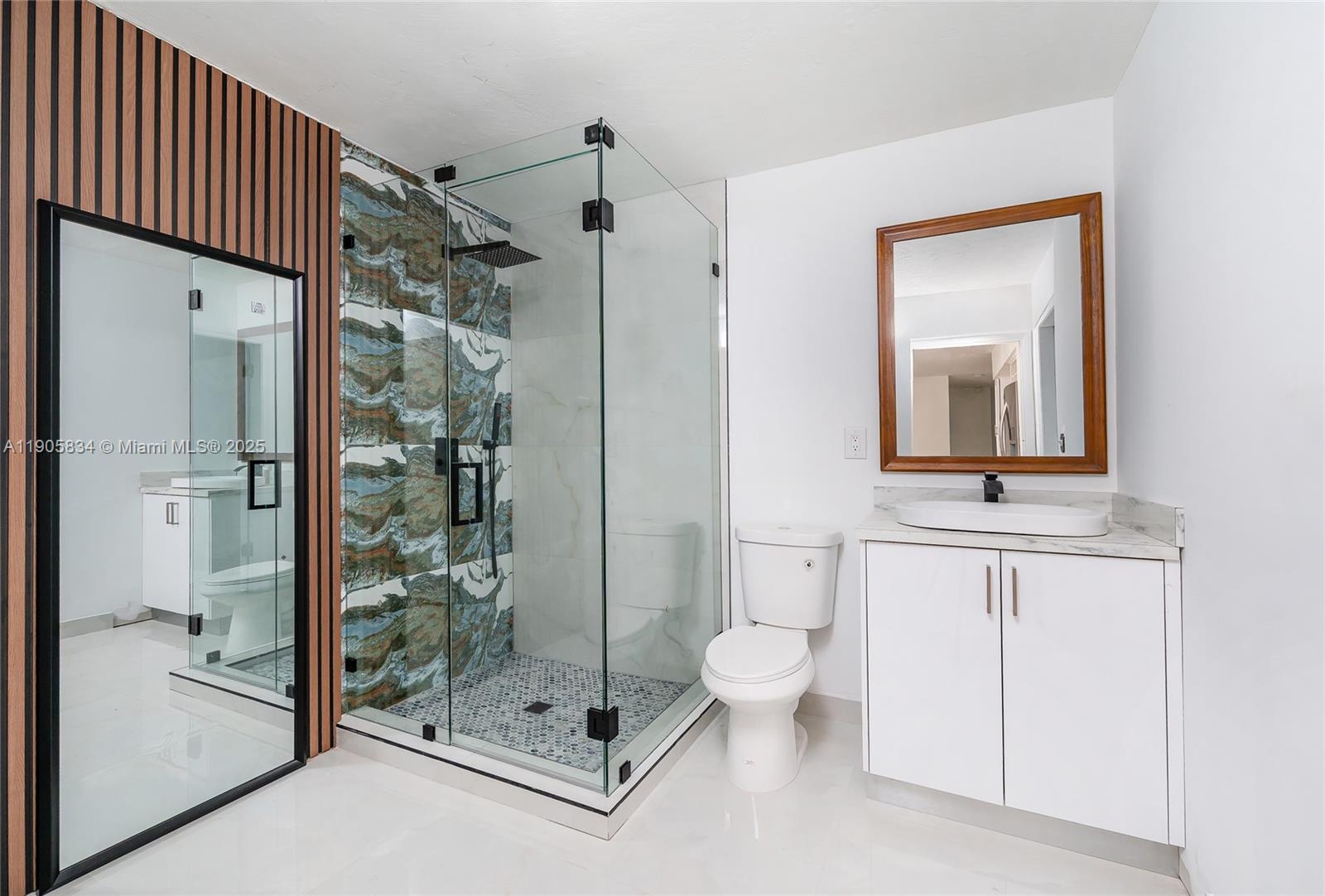 5420 Northwest 182nd Street Miami Gardens, FL 33055 - Photo 16 of 35 a bathroom with a shower a sink and mirror