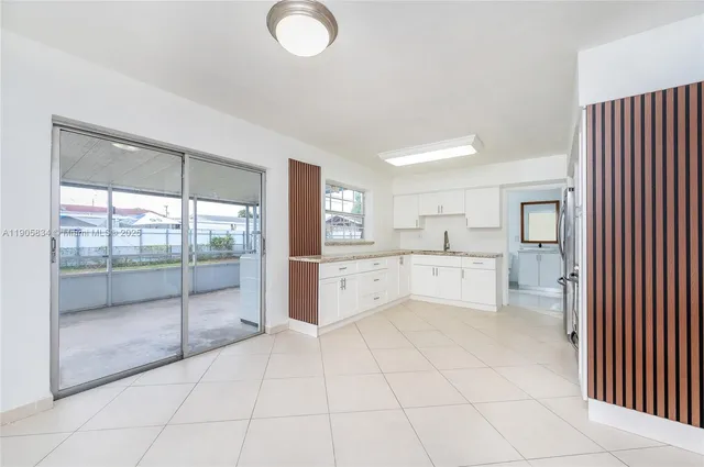 a kitchen with granite countertop white cabinets and stainless steel appliances