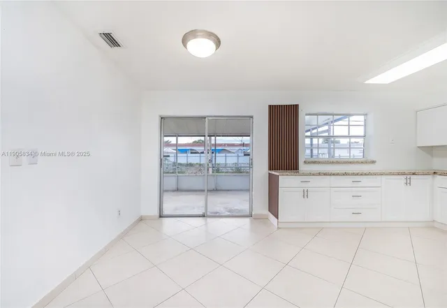 an empty room with a ceiling fan and carpet