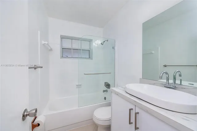 a view of an empty room with chandelier fan