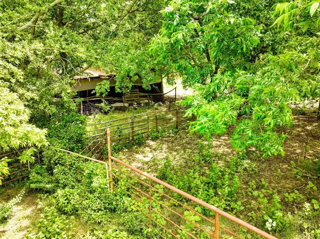 a backyard of a house with lots of green space and fountain