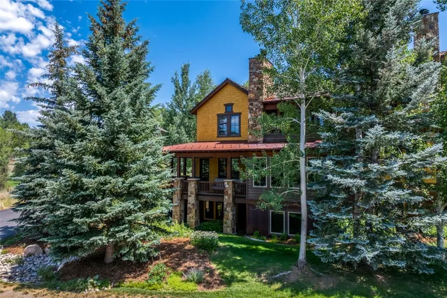 a view of a house with a small yard and a tree