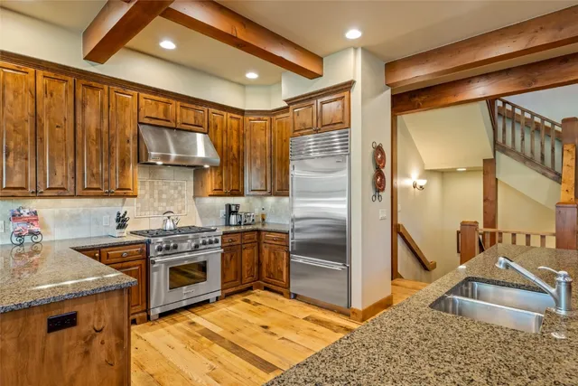 a kitchen with stainless steel appliances granite countertop a sink stove and refrigerator