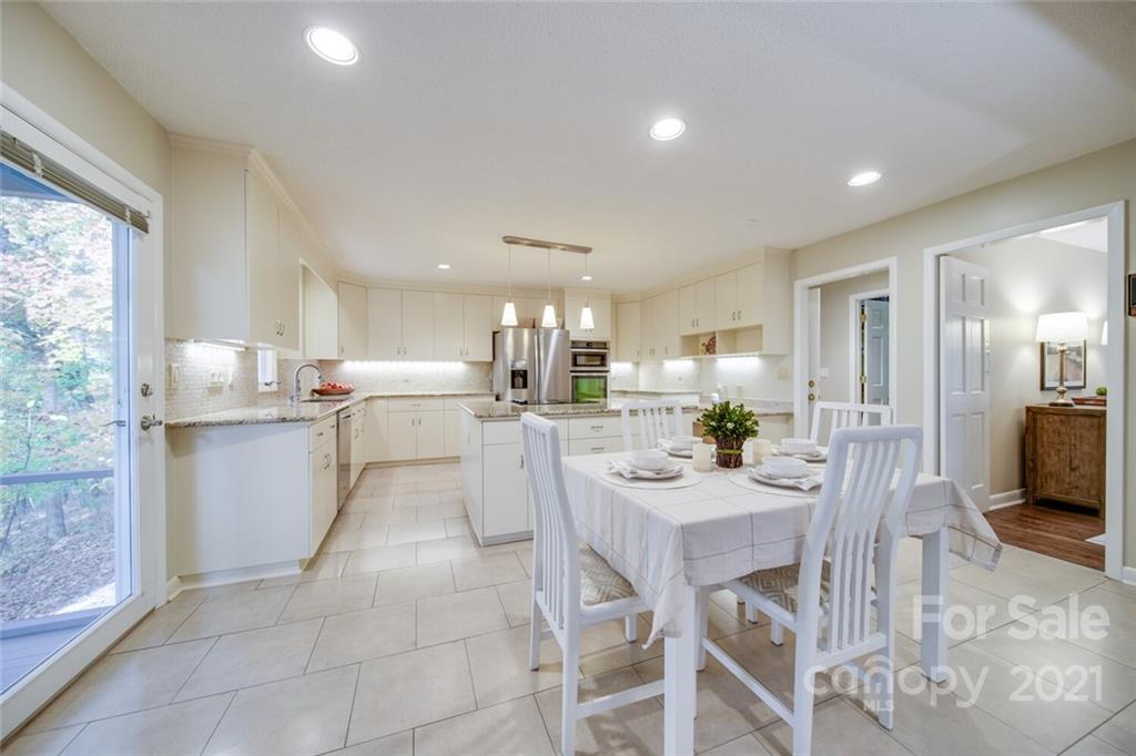 105 Den Road Wadesboro, NC 28170 - Photo 19 of 47 a kitchen with a dining table chairs and white cabinets