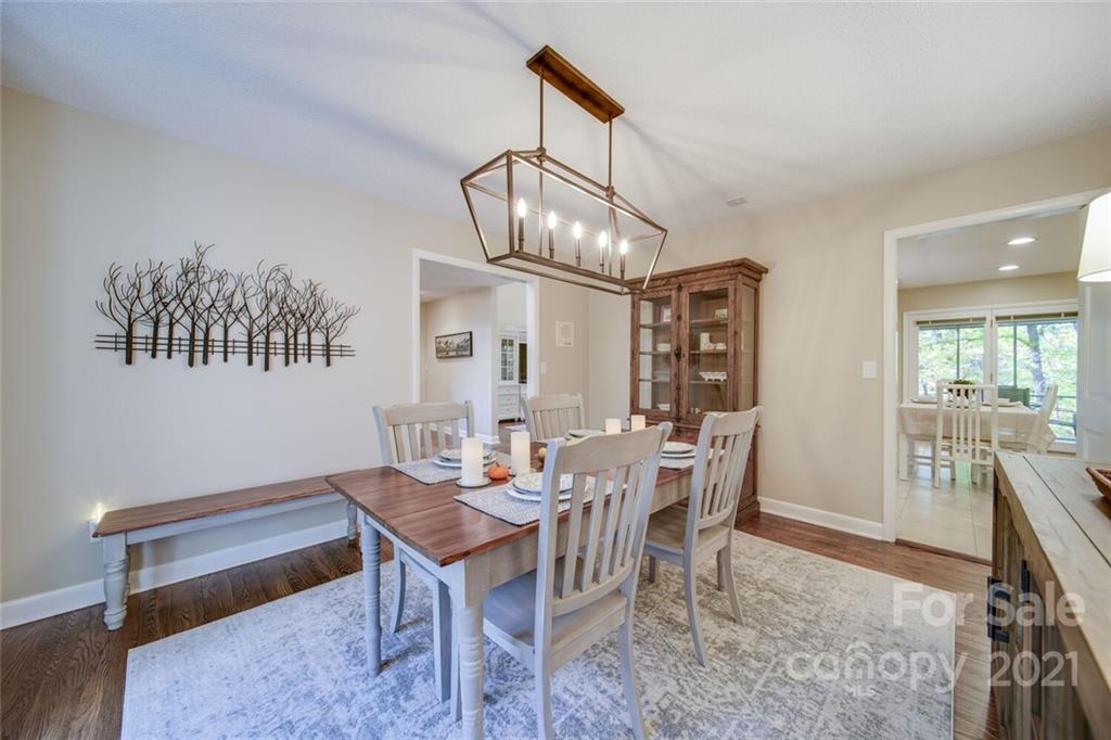 105 Den Road Wadesboro, NC 28170 - Photo 28 of 47 a dining room with wooden floor a chandelier a wooden table and chairs