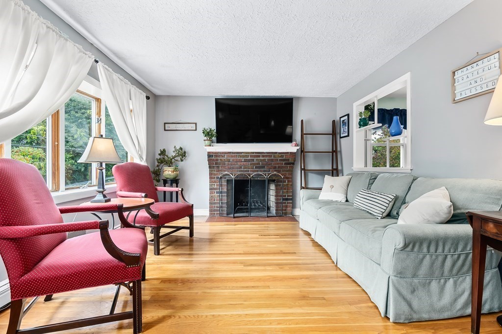 195 Den Quarry Road Lynn, MA 01904 - Photo 2 of 28 a living room with furniture a flat screen tv and a fireplace