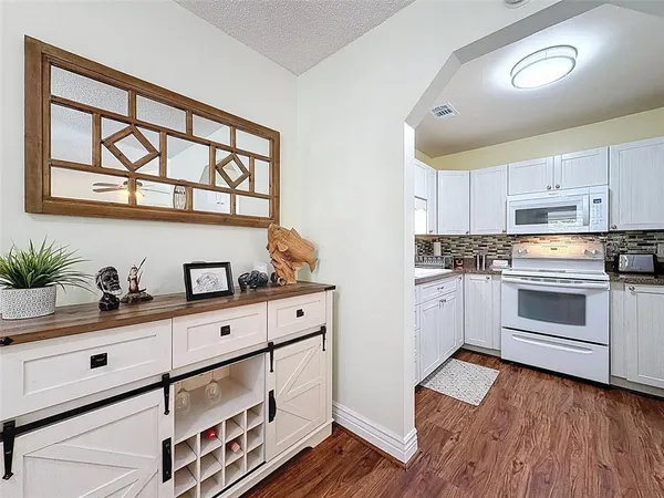 a kitchen with granite countertop white cabinets and white appliances