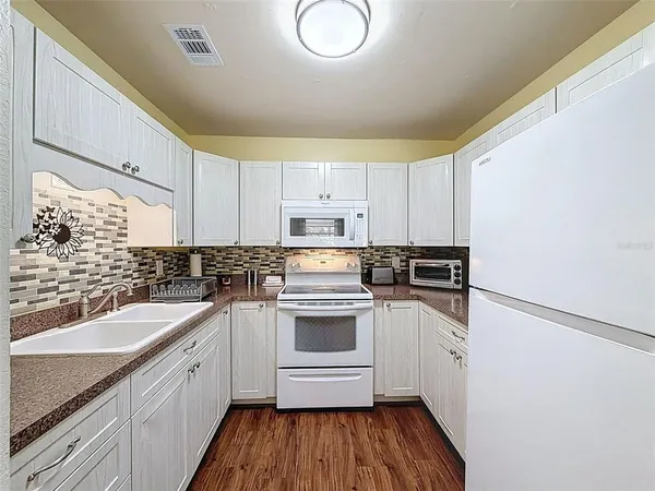 a kitchen with a sink cabinets stainless steel appliances and a window