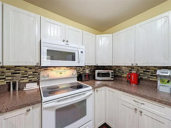 a kitchen with sink cabinets and white appliances