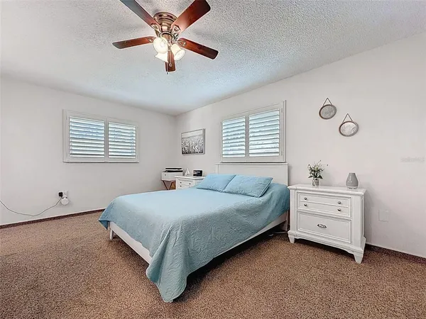 a bedroom with a bed and a ceiling fan