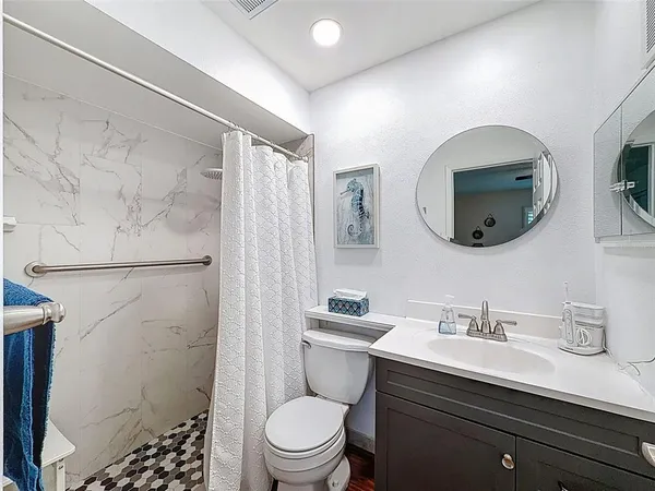 a bathroom with a sink a toilet and shower