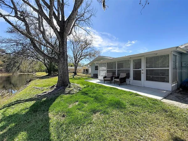 a view of a house with backyard and sitting area