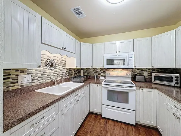 a kitchen with a sink stove and cabinets