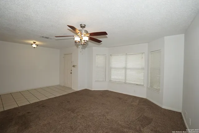 an empty room with a empty space and a ceiling fan
