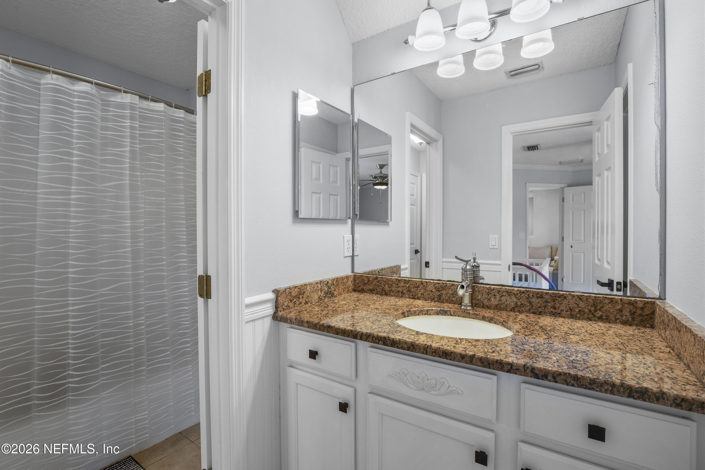 3020 South Atherley Road St. Augustine, FL 32092 - Photo 32 of 61 a bathroom with a granite countertop sink a large mirror and shower