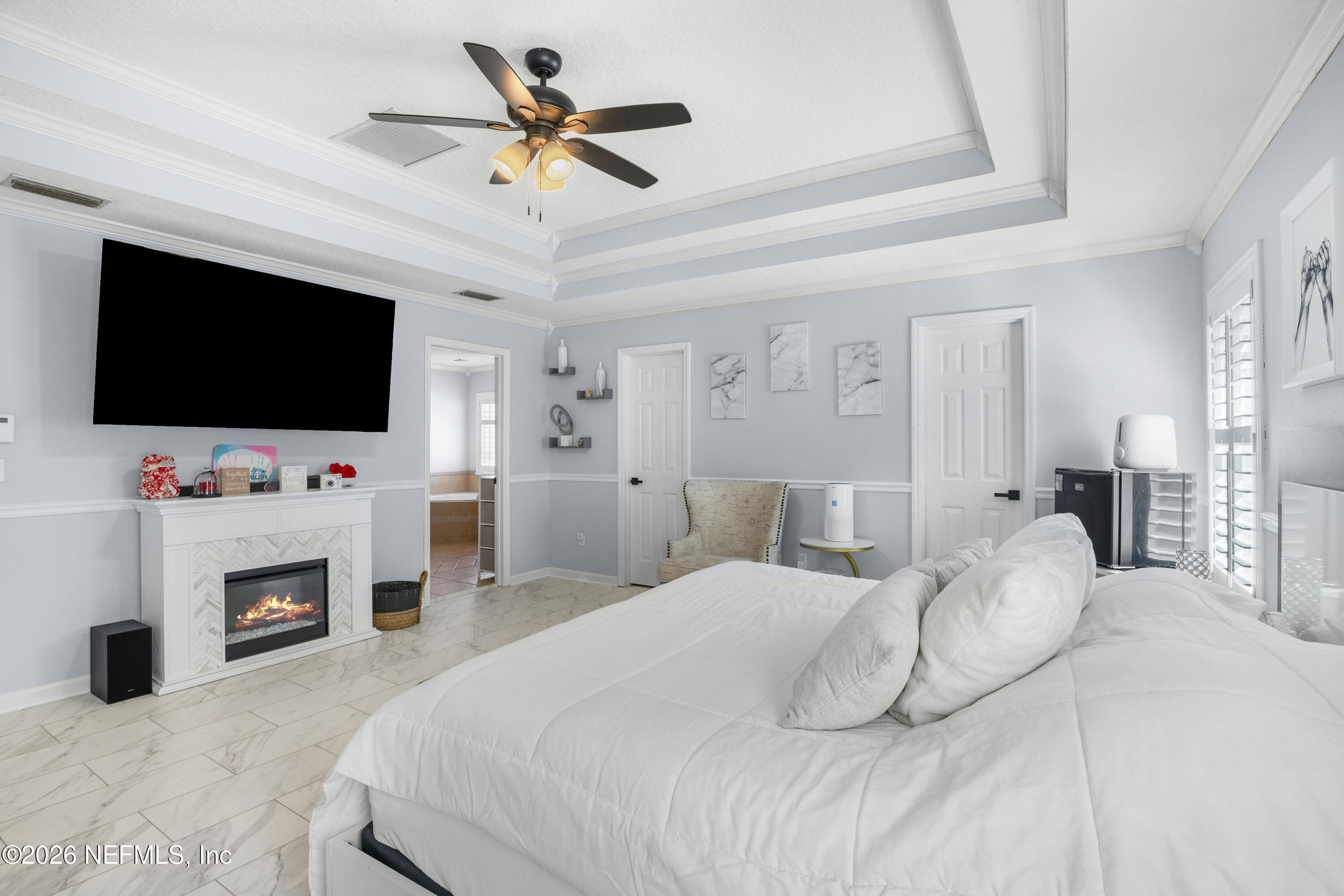 3020 South Atherley Road St. Augustine, FL 32092 - Photo 40 of 61 a bedroom with a bed a flat tv screen and a fireplace