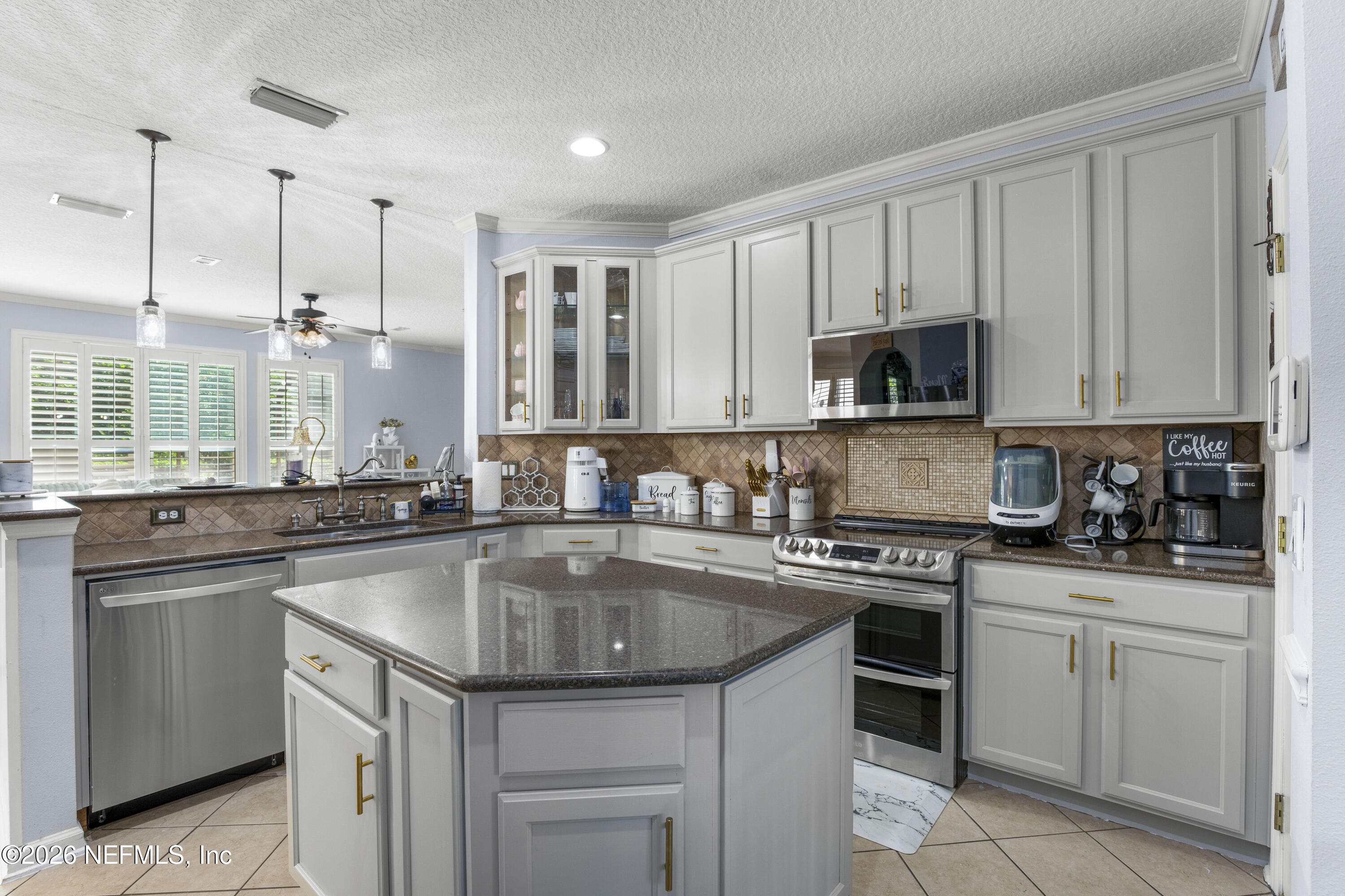 3020 South Atherley Road St. Augustine, FL 32092 - Photo 4 of 61 a kitchen with kitchen island granite countertop a sink a stove and cabinets