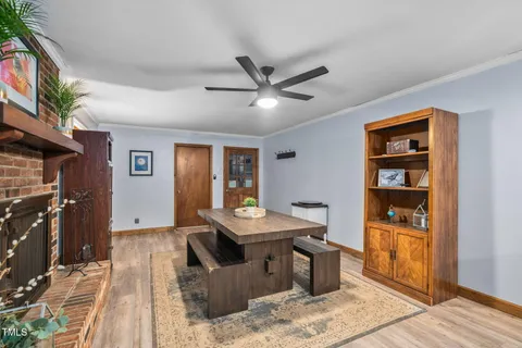 a living room with stainless steel appliances furniture a fireplace and a open kitchen view