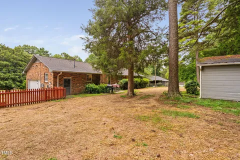 a view of a house with backyard and trees