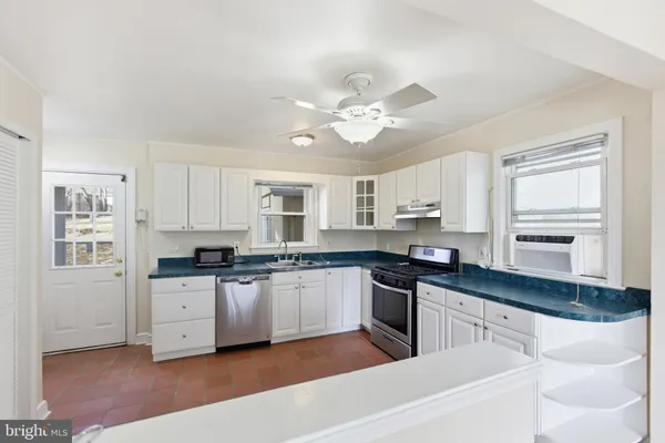 a kitchen with white cabinets and appliances