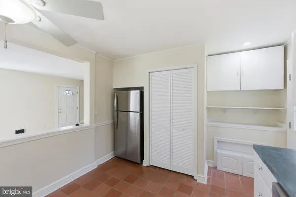 a view of an empty room with closet and a window
