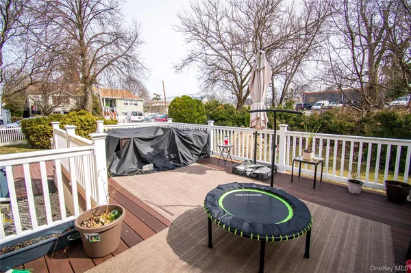 a patio table and chairs with wooden floor and fence