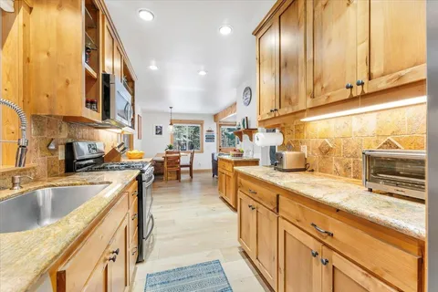 a kitchen with stainless steel appliances granite countertop sink stove and cabinets
