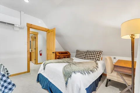 a bedroom with a bed and a lamp with the wooden floor