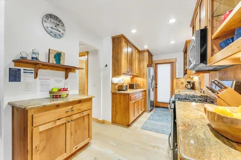 a kitchen with stainless steel appliances granite countertop a stove a sink and a refrigerator