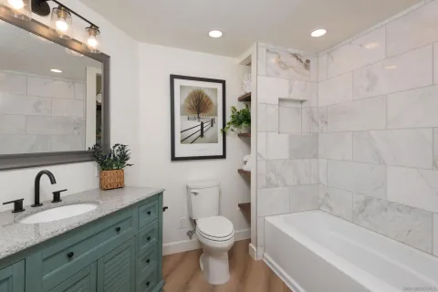a bathroom with a toilet a sink a mirror a bathtub and shower