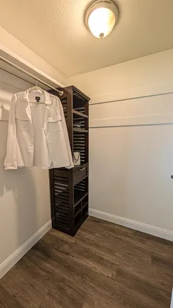 a view of walk in closet with clothes and shoes