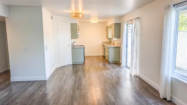 a view of a kitchen with wooden floor and a refrigerator