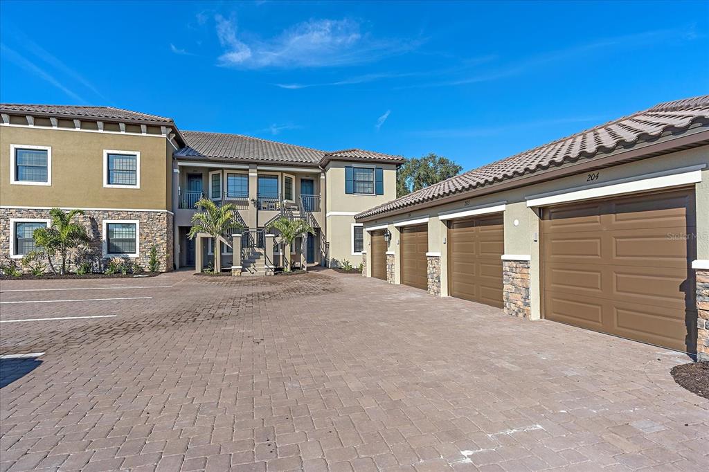 12410 Osorio Court, Unit 201 Sarasota, FL 34238 - Photo 20 of 42 a front view of a house with glass windows and brick wall