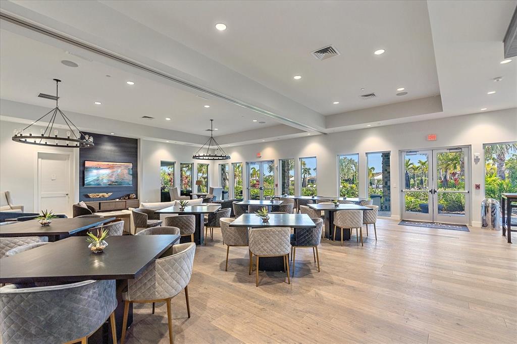 12410 Osorio Court, Unit 201 Sarasota, FL 34238 - Photo 26 of 42 a room with lots of tables a large window and chairs