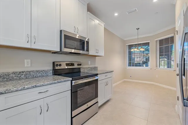 a kitchen with stainless steel appliances granite countertop a stove a sink and a microwave