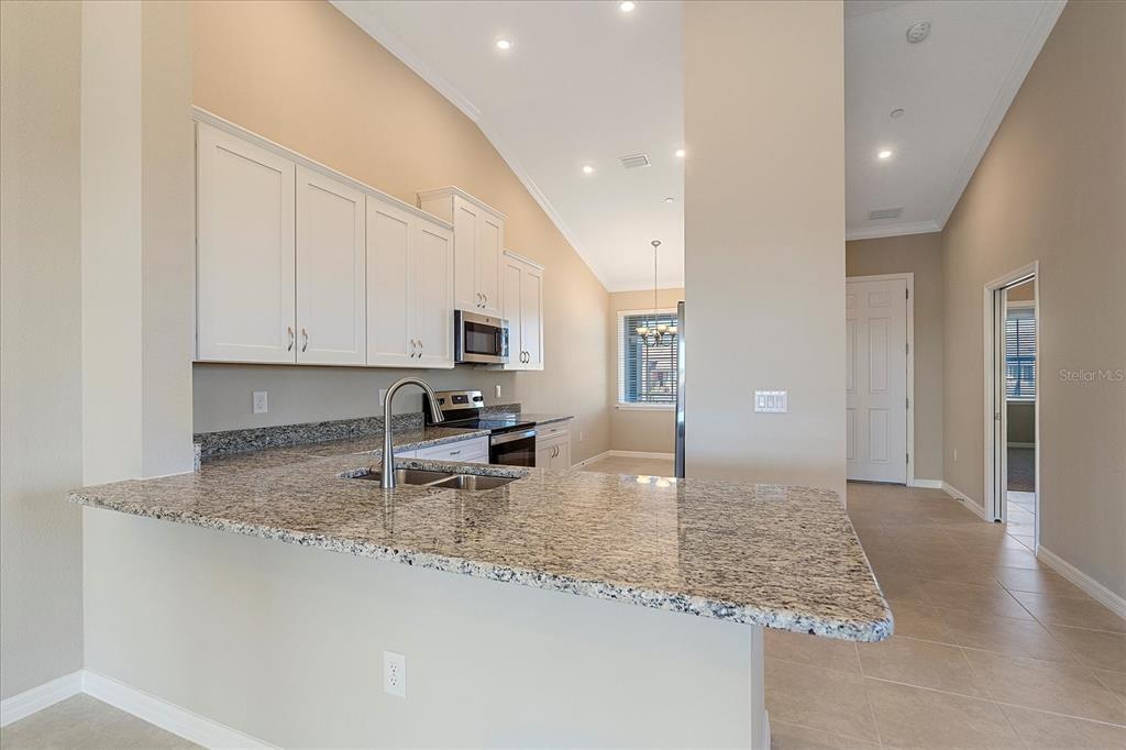 12410 Osorio Court, Unit 201 Sarasota, FL 34238 - Photo 6 of 42 a kitchen with granite countertop white cabinets and granite counter tops
