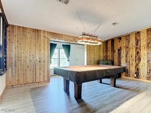 a room with wooden floors table and chairs