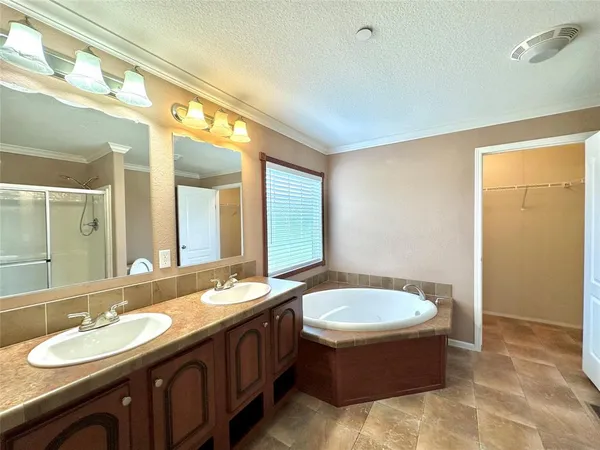 a bathroom with a tub double sink and mirror