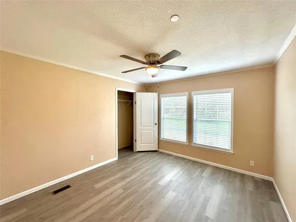 an empty room with wooden floor and windows