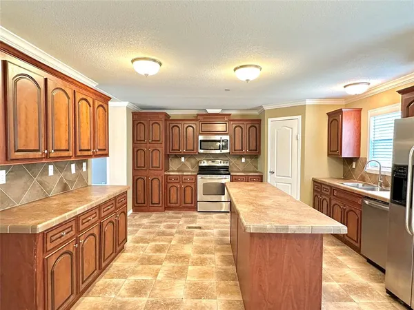 a large kitchen with stainless steel appliances kitchen island granite countertop a large counter top cabinets and stainless steel appliances