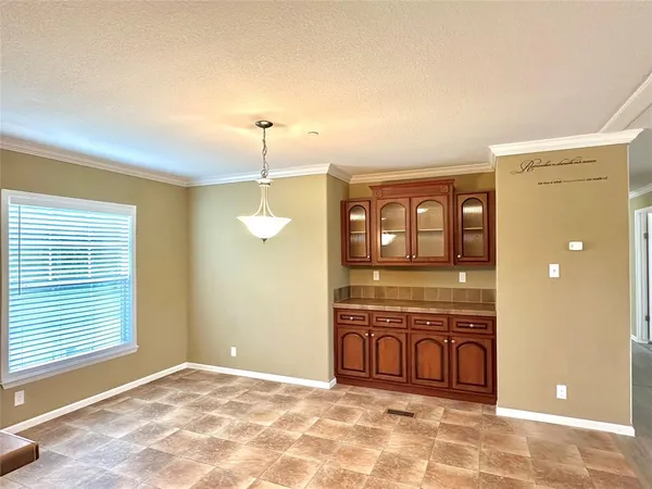 a view of a hallway with granite countertop a couch and chandelier