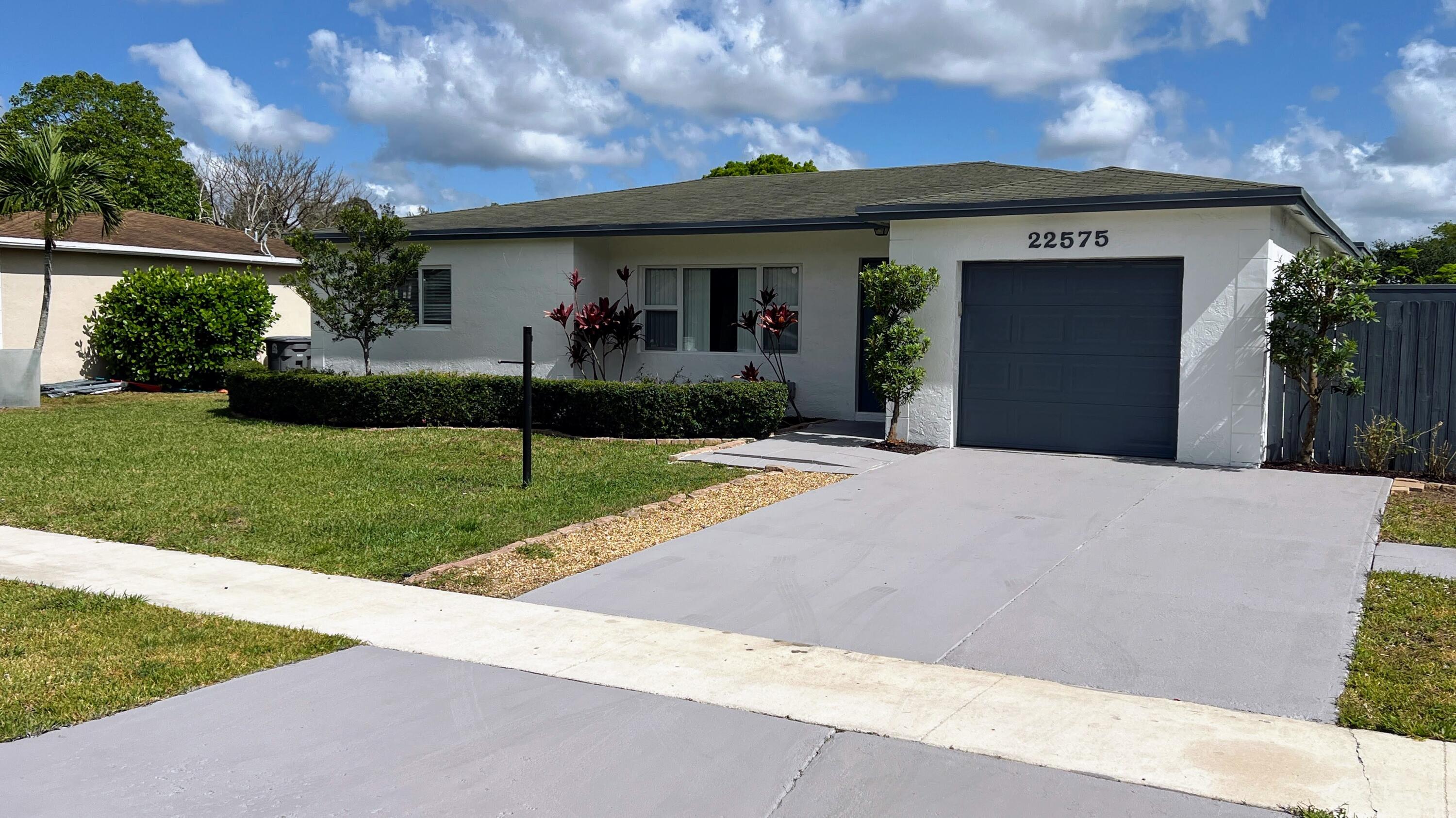 22575 Lanyard Street Boca Raton, FL 33428 - Photo 5 of 27 a front view of a house with a yard