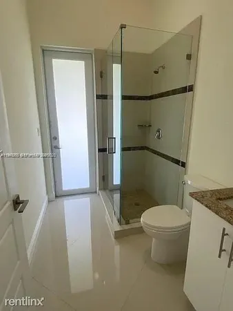 a bathroom with a toilet and a shower