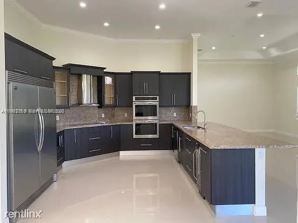 a large kitchen with stainless steel appliances kitchen island granite countertop a large counter top cabinets and stainless steel appliances