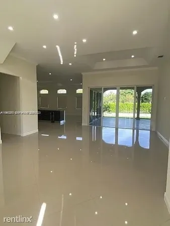 a view of a big room with large windows and chandelier