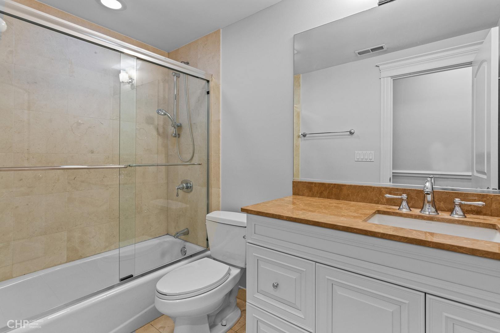 1049 West Monroe Street, Unit 1 Chicago, IL 60607 - Photo 16 of 22 a bathroom with a granite countertop sink a toilet and shower