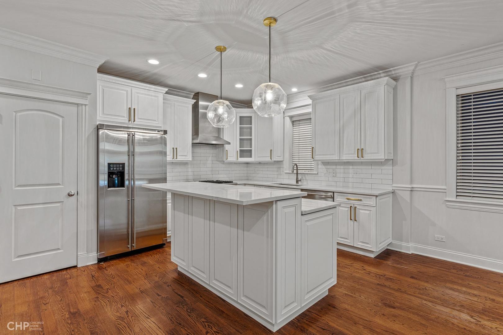 1049 West Monroe Street, Unit 1 Chicago, IL 60607 - Photo 6 of 22 a large kitchen with granite countertop a white stove top oven and refrigerator