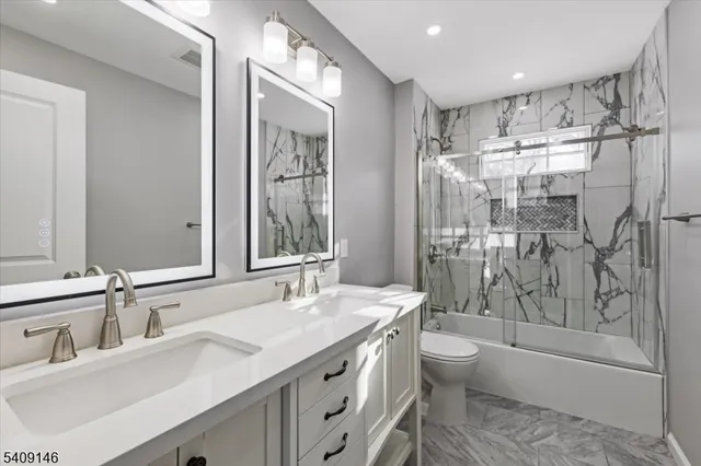 a bathroom with a granite countertop sink toilet and shower