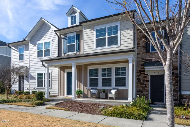 a front view of a house with a yard and glass windows